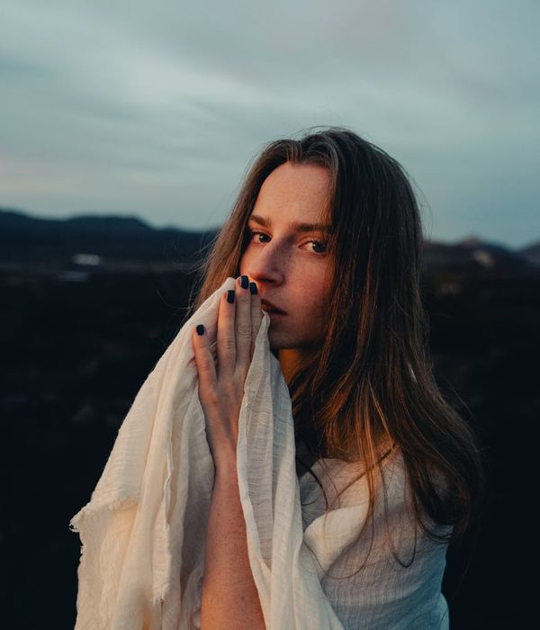 Woman with a calm and focused expression, surrounded by soft light.